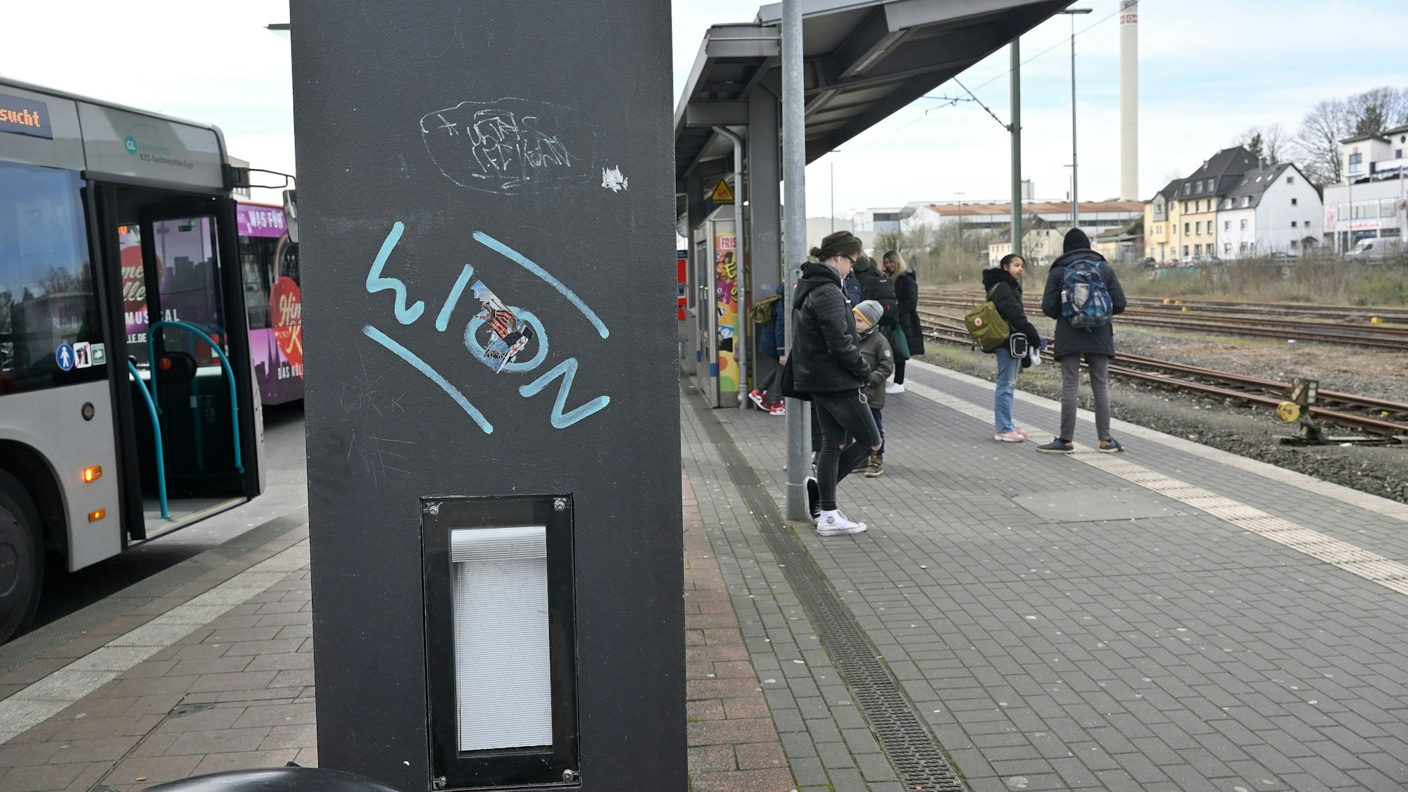 Menschen stehen am Bahnhof.