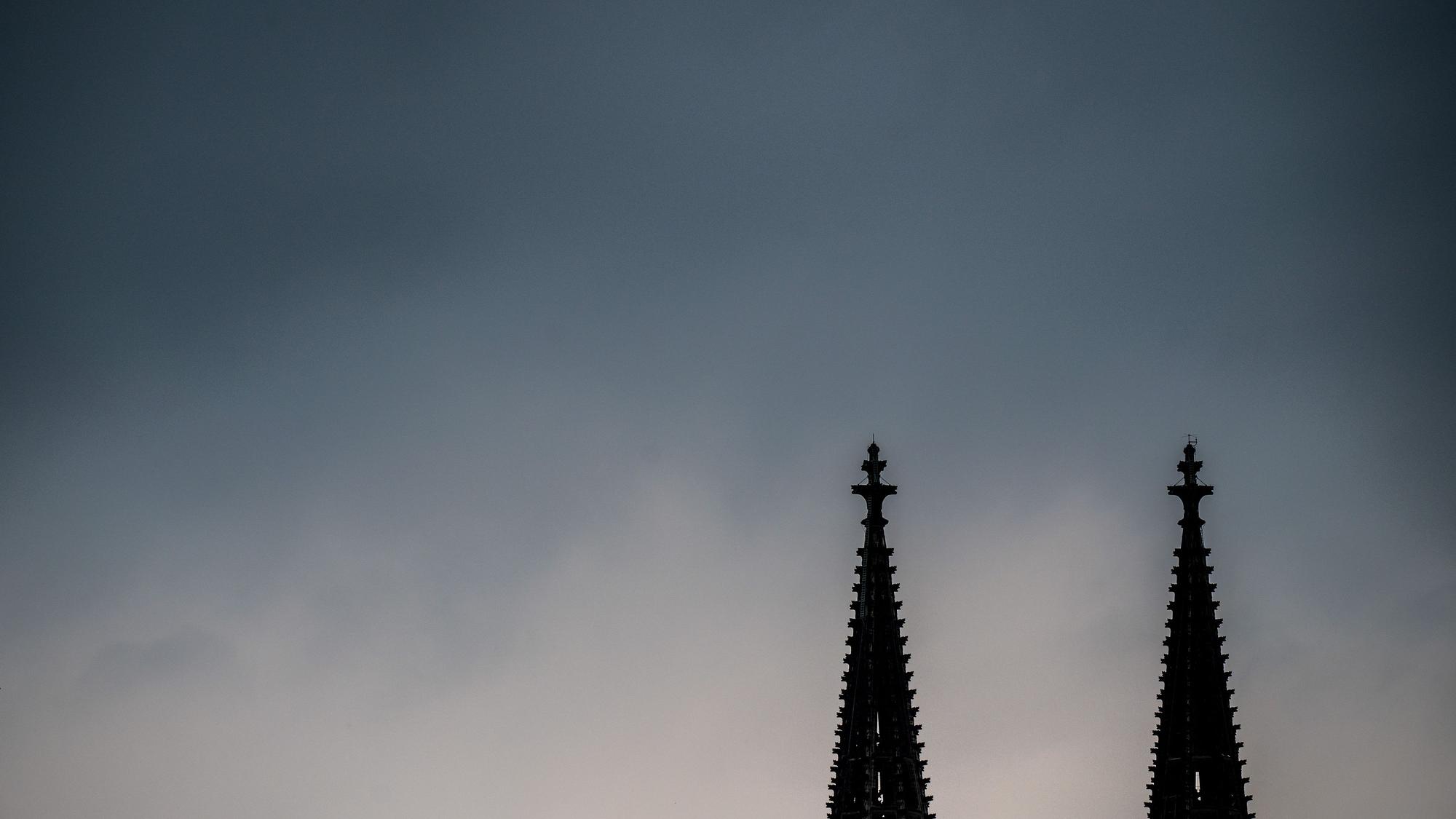 Dunkle Gewitterwolken ziehen über den Spitzen des Kölner Doms