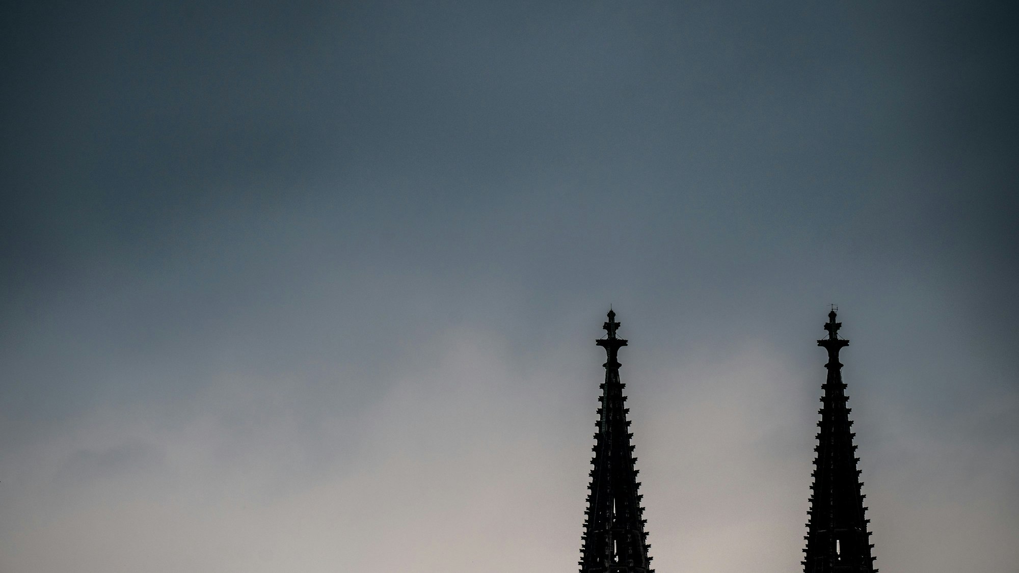 Dunkle Gewitterwolken ziehen über den Spitzen des Kölner Doms