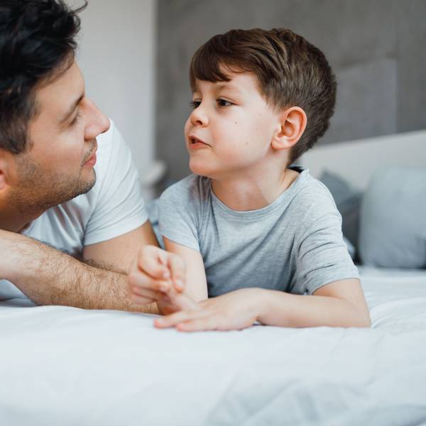 Father and his 7 years old son are talking in the bed. Foto: Getty Images/Georgijevic