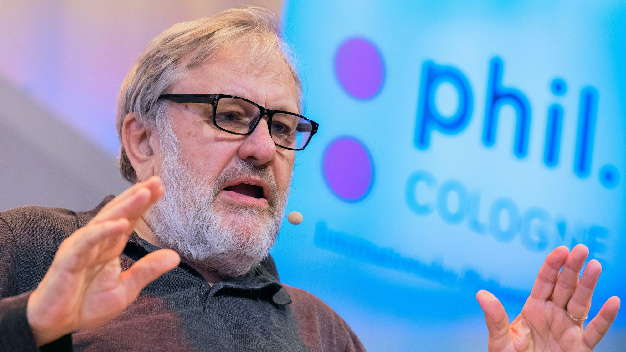 Slavoj Zizek spricht, hinter ihm auf einer Leinwand die Aufschrift phil. Cologne.