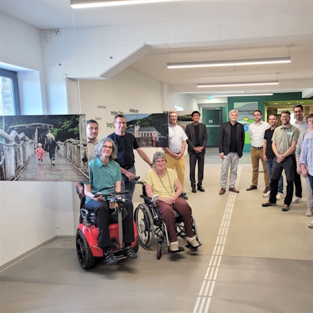 Eine Gruppe Menschen ist im Halbkreis zusammen.