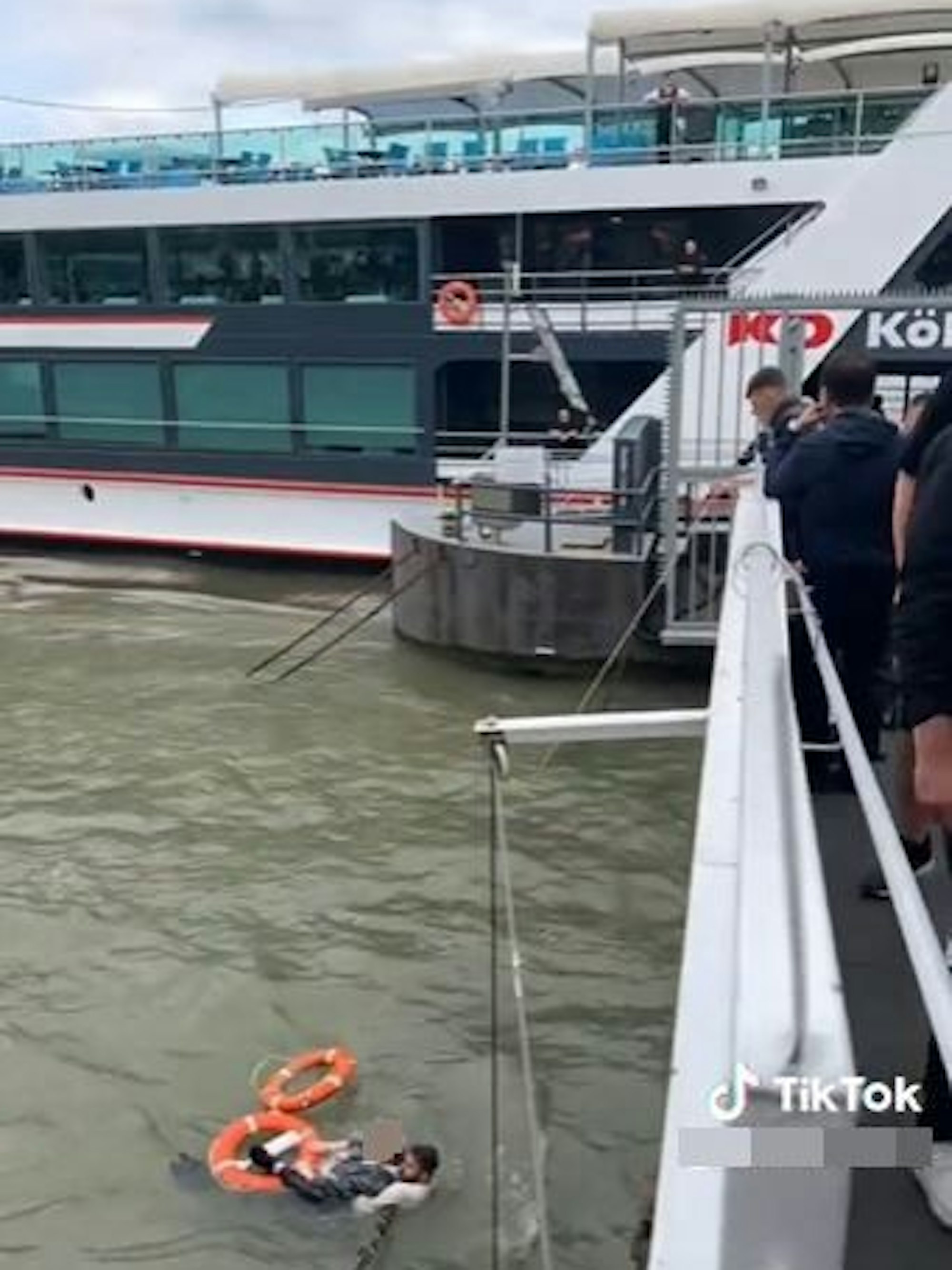 Vom Bootsanleger aus sieht man zwei Männer im Rhein.