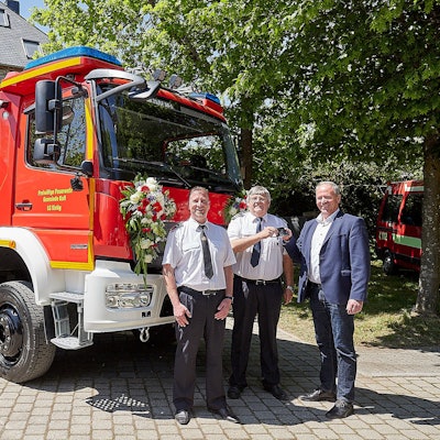 Löschgruppenführer Jochen Völler (v.l.), Kalls Feuerwehrchef Harald Heinen und Kalls Bürgermeister Hermann-Josef Esser stehen vor dem neuen Feuerwehrfahrzeug. Esser übergibt Heinen den Schlüssel.