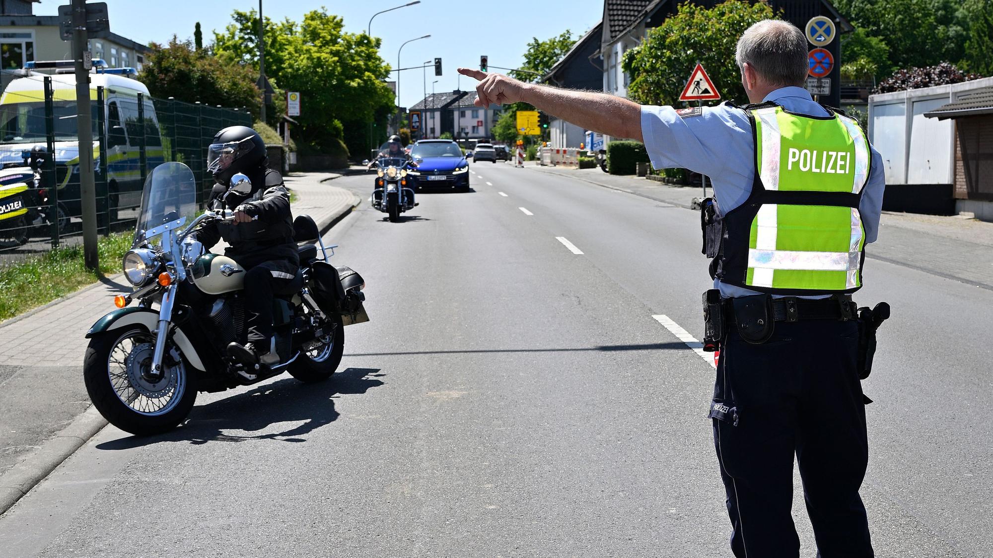 Ein Polizist weist einem Motorradfahrer an, an den Straßenrand zu fahren.