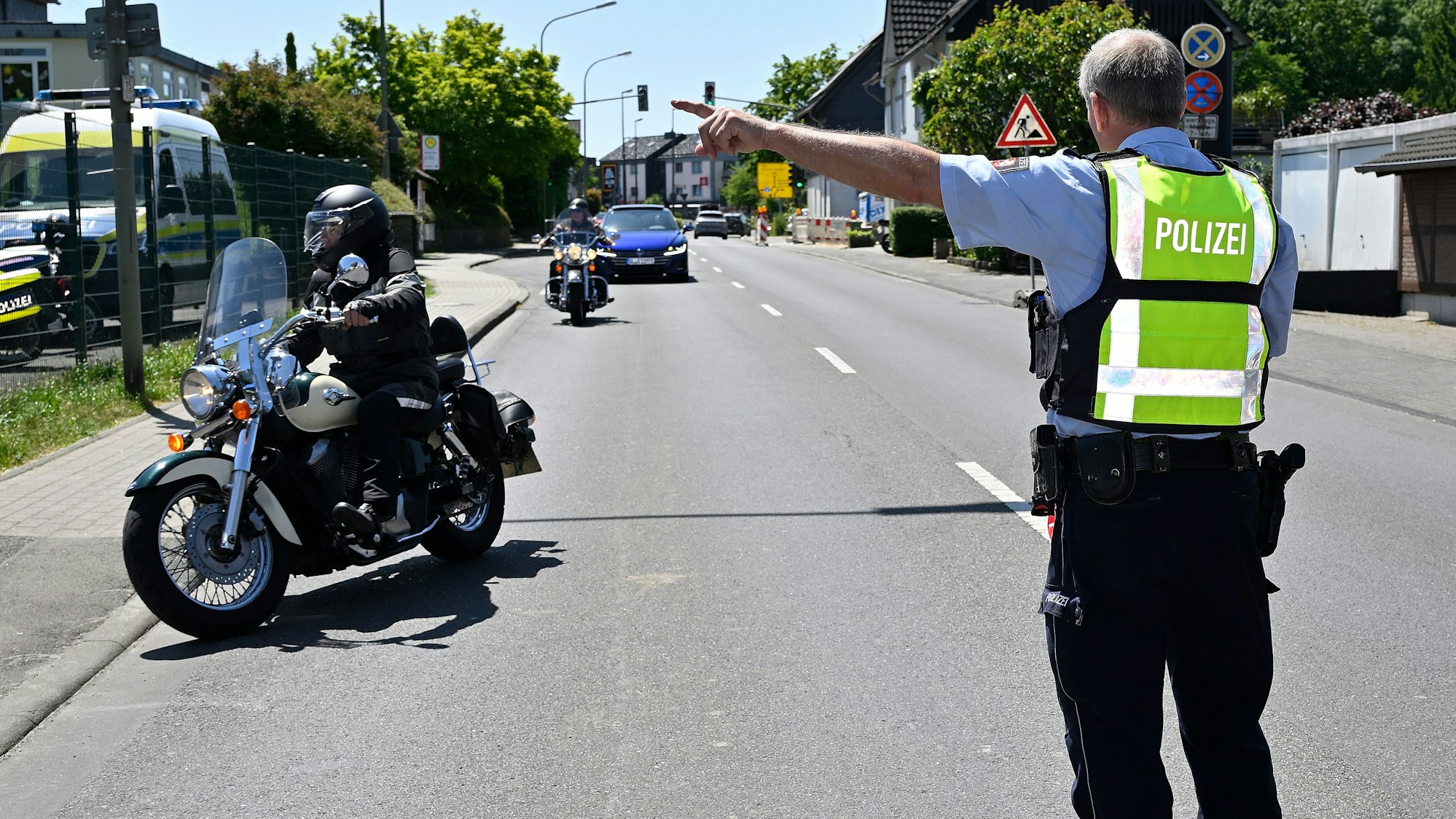 Ein Polizist weist einem Motorradfahrer an, an den Straßenrand zu fahren.
