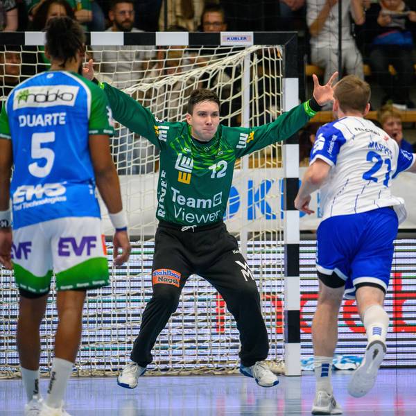 Ein Handballtorhüter ist bei einer Parade zu sehen.