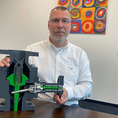 Firmenchef Axel Mücher mit dem Modell eines Freilauf-Rückschlagventils.