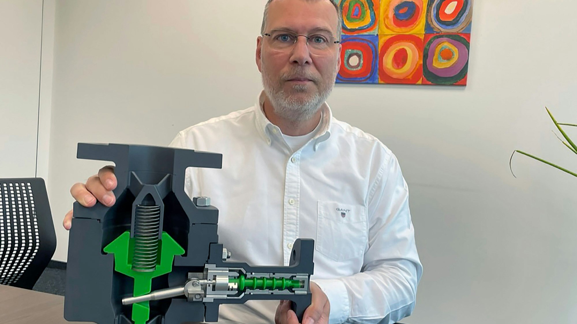 Firmenchef Axel Mücher mit dem Modell eines Freilauf-Rückschlagventils.