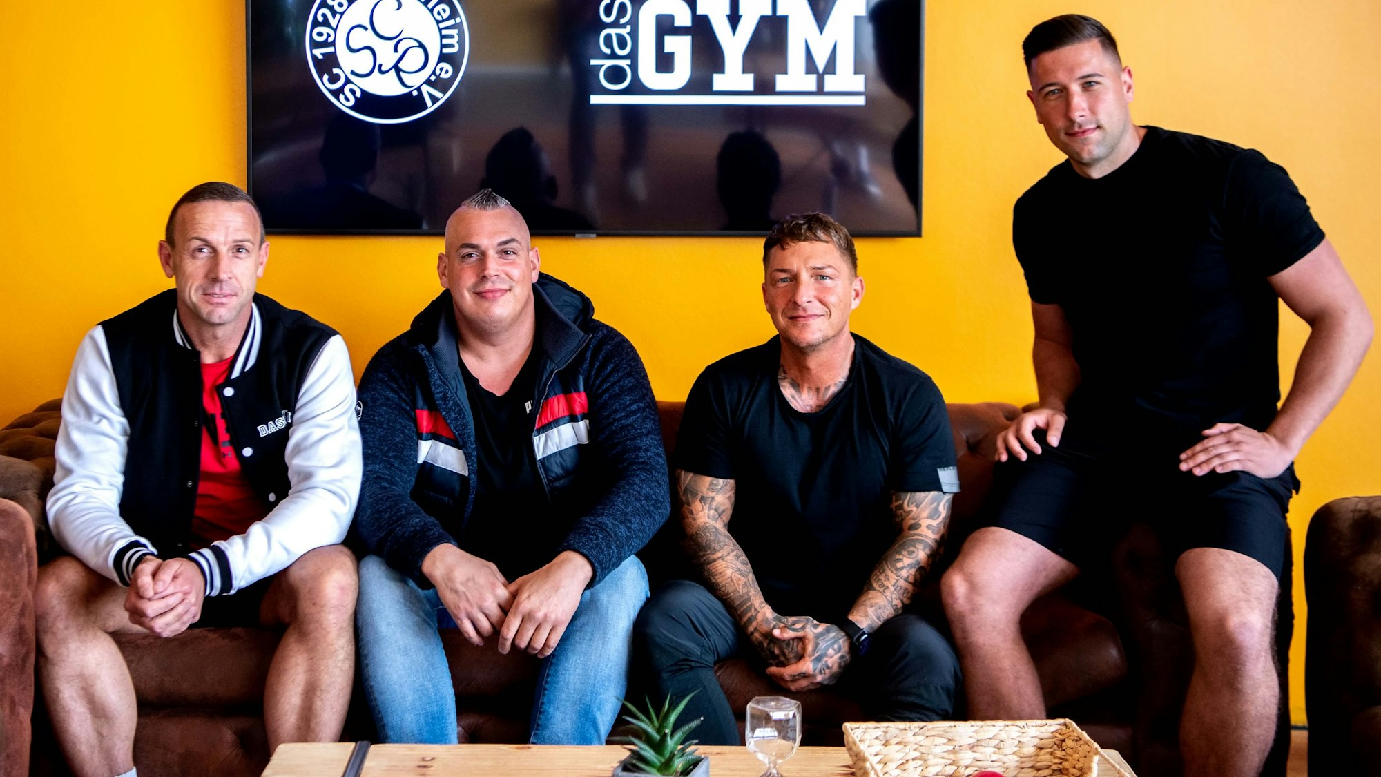 Die Macher des Projekts sitzen auf einer Couch: Thomas Klöcker, Trainer Timo Eschweiler, Sponsor Michael Schlögel und Spieler Dominik Hochgürtel.