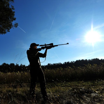 Eine Jägerin zielt mit ihrem Gewehr in einem Waldstück bei Lüneburg.
