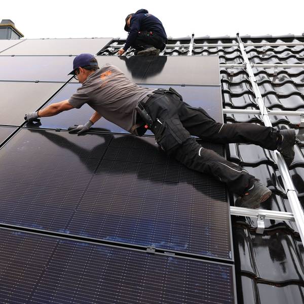 18.08.2022, Nordrhein-Westfalen, Nettersheim: Handwerker montieren auf dem Dach eines Wohnhauses Solarmodule. Foto: Oliver Berg/dpa +++ dpa-Bildfunk +++