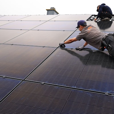 18.08.2022, Nordrhein-Westfalen, Nettersheim: Handwerker montieren auf dem Dach eines Wohnhauses Solarmodule. Foto: Oliver Berg/dpa +++ dpa-Bildfunk +++