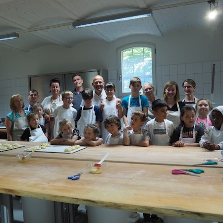 Die Back-AG der Gymnicher Grundschule in der Lehrbäckerei mit Landrat Frank Rock.