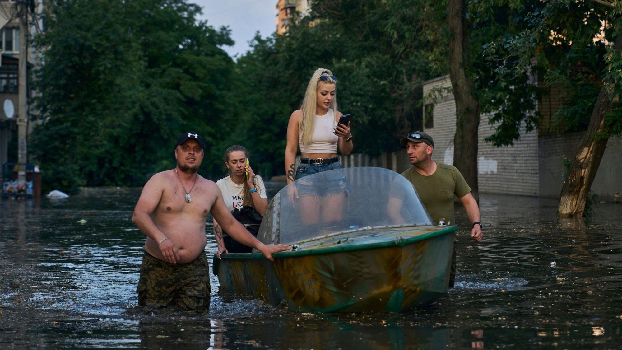 Rettungskräfte transportieren Bewohner mit Booten, die aus einem überfluteten Viertel in Cherson evakuiert werden sollen. Der russische Angriffskrieg gegen die Ukraine ist durch die Sprengung des wichtigen Kachowka-Staudamms gefährlich eskaliert.
