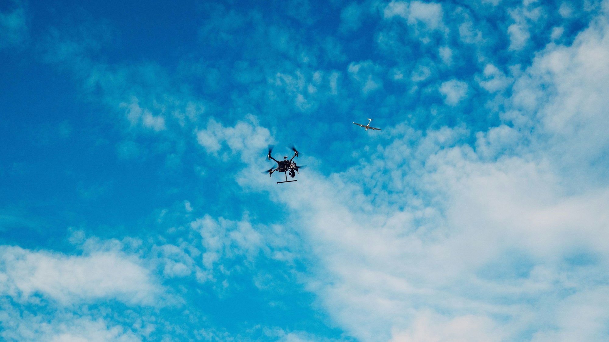 Es ist eine Drohne und ein Flugzeug zu sehen.