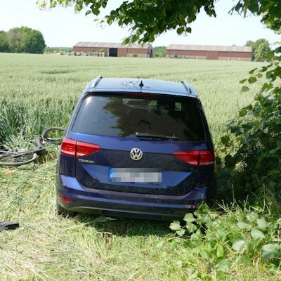 Ein E-Bike liegt neben einem Auto.