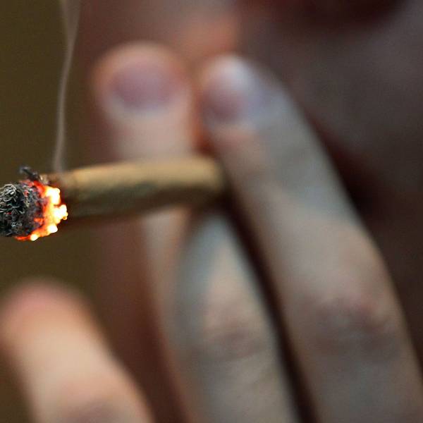 Ein Mann raucht einen Joint mit Marihuana.