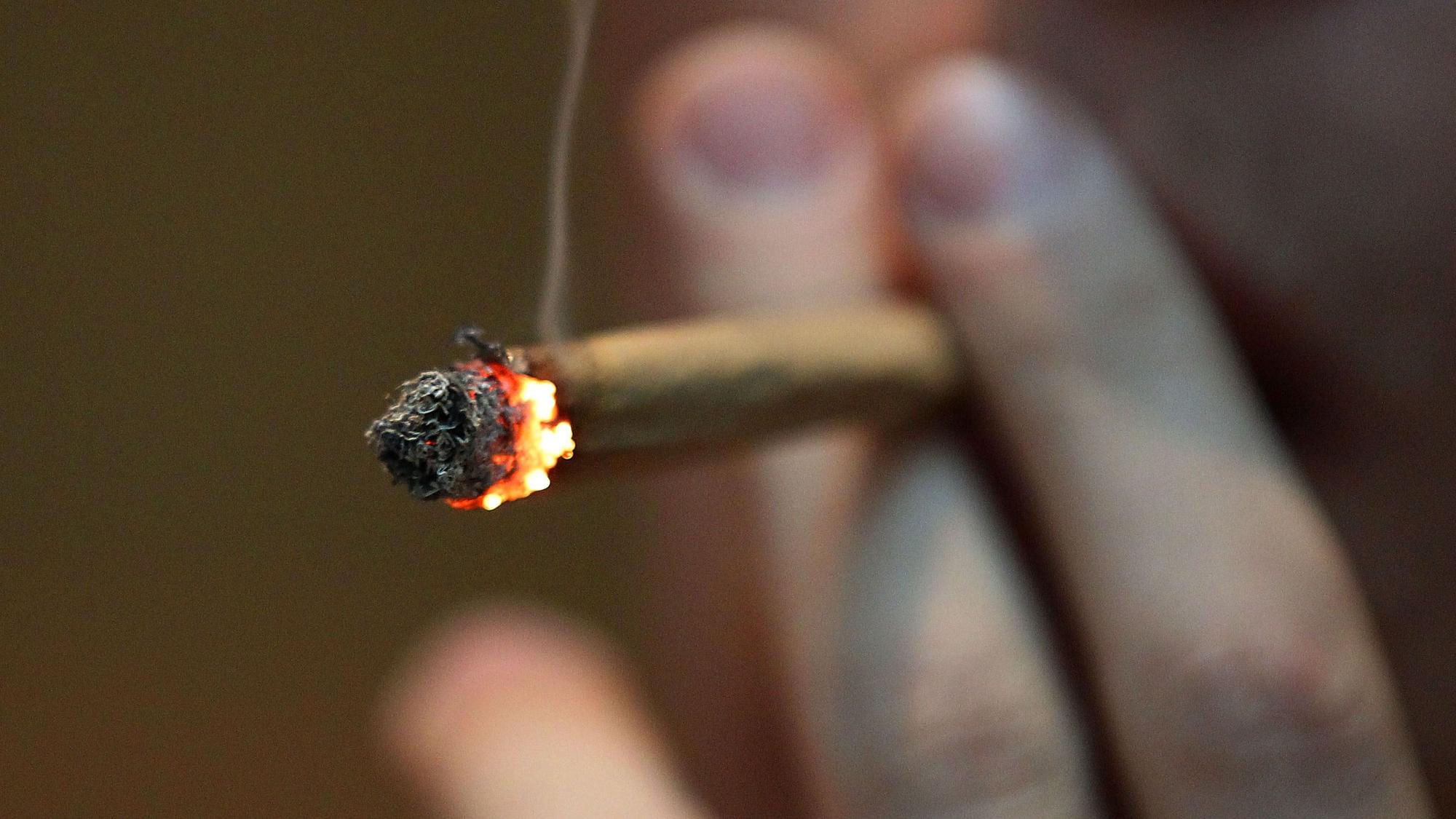Ein Mann raucht einen Joint mit Marihuana.
