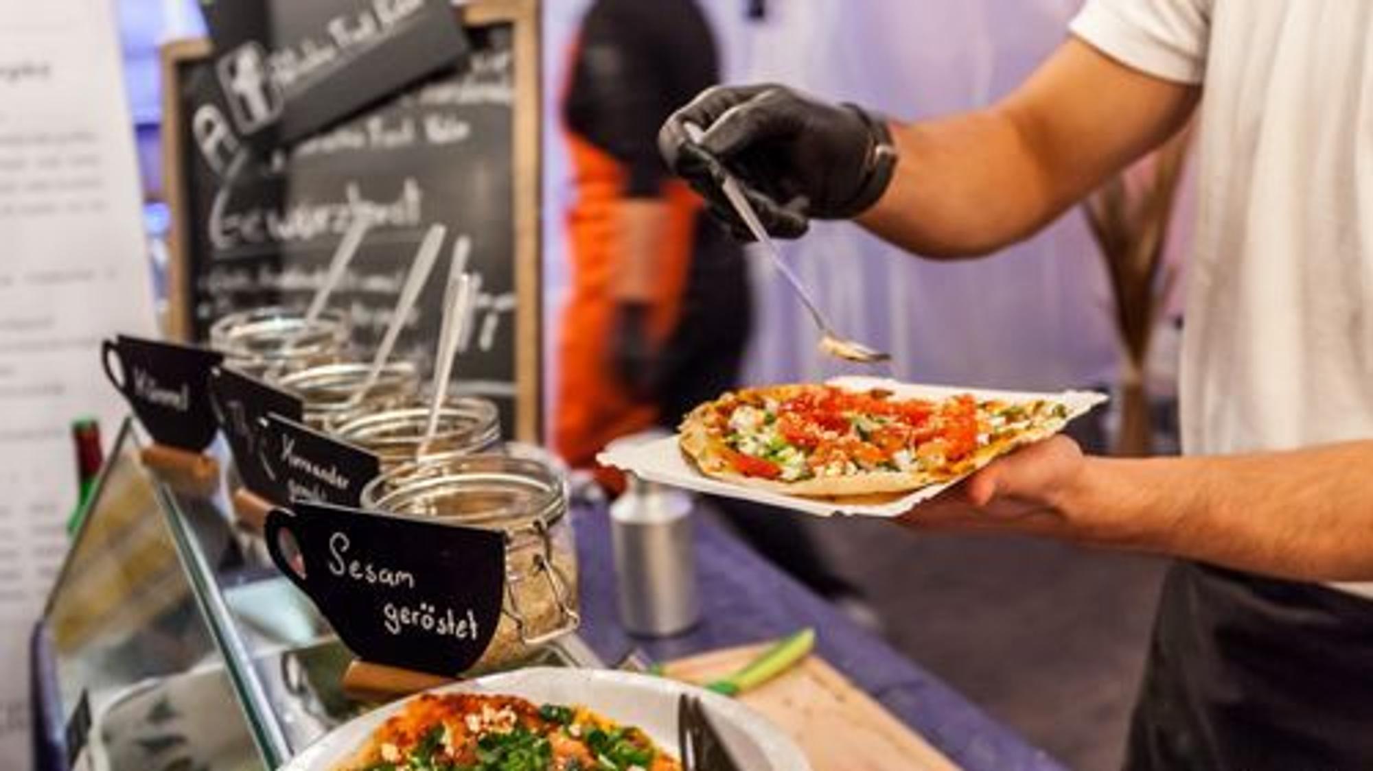 Ein Mann hält eine Pizza.