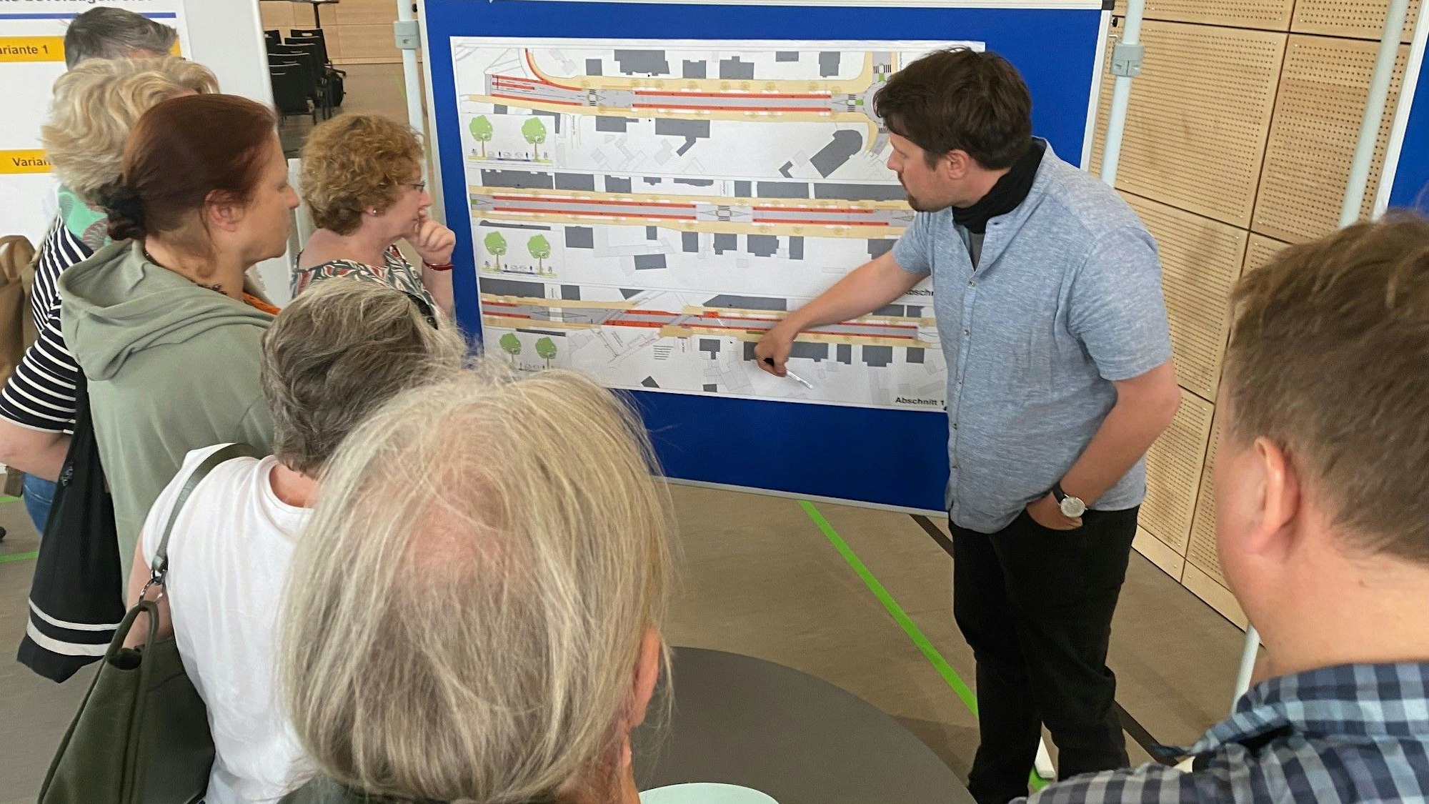 Das Foto zeigt Anwohner, die sich von einem Experten die Ideen für die Neugestaltung der Pingsdorfer Straße zeigen lassen.