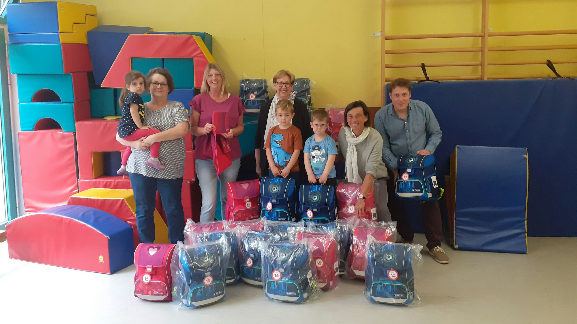 Die Beteiligten freuten sich über die 123 Schulranzen. Die beschenkten Kinder waren nicht anwesend.