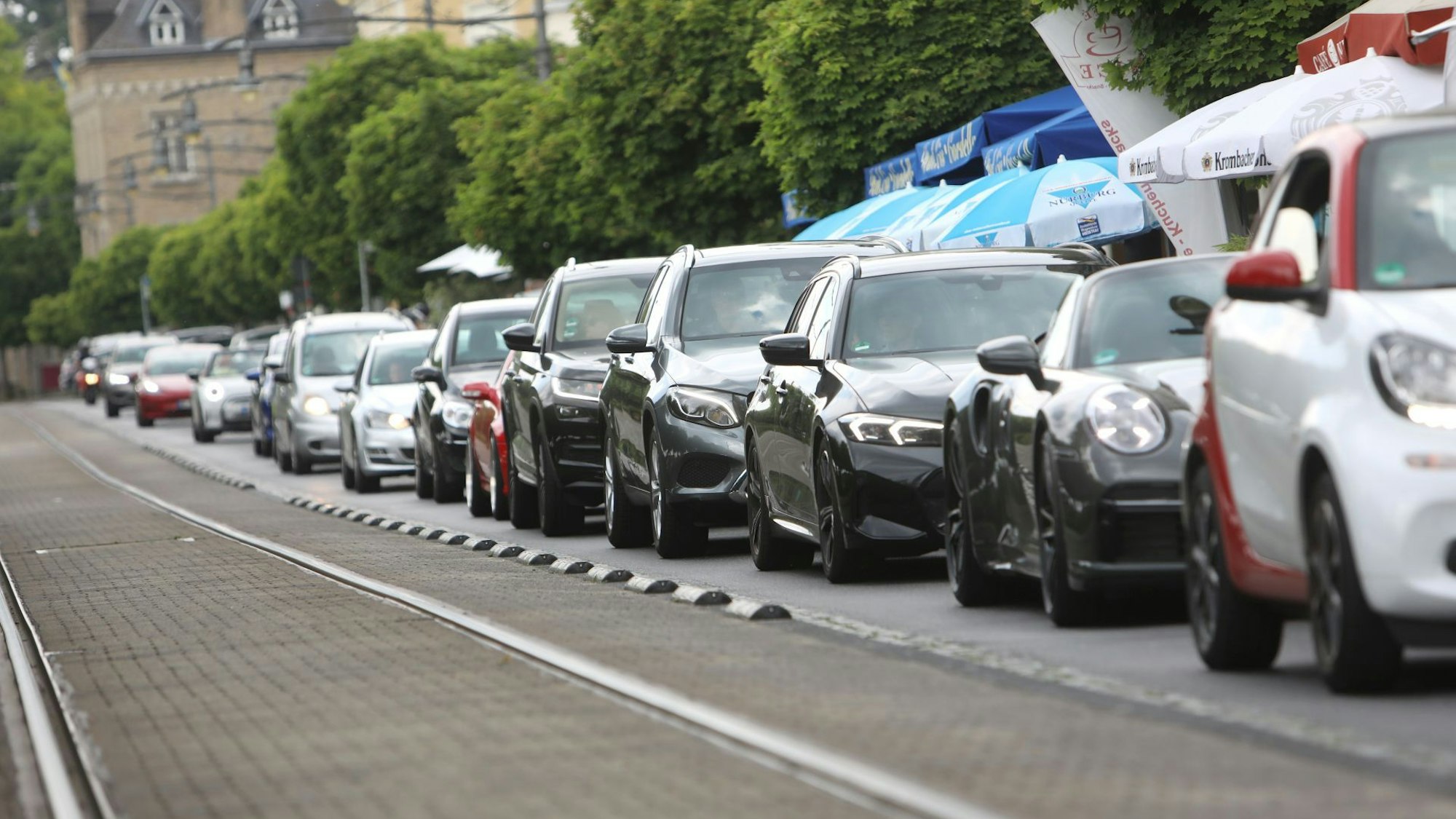 Neben einer Trasse für die Stadtbahnlinie stehen Autos in einer langen Schlange hintereinander.