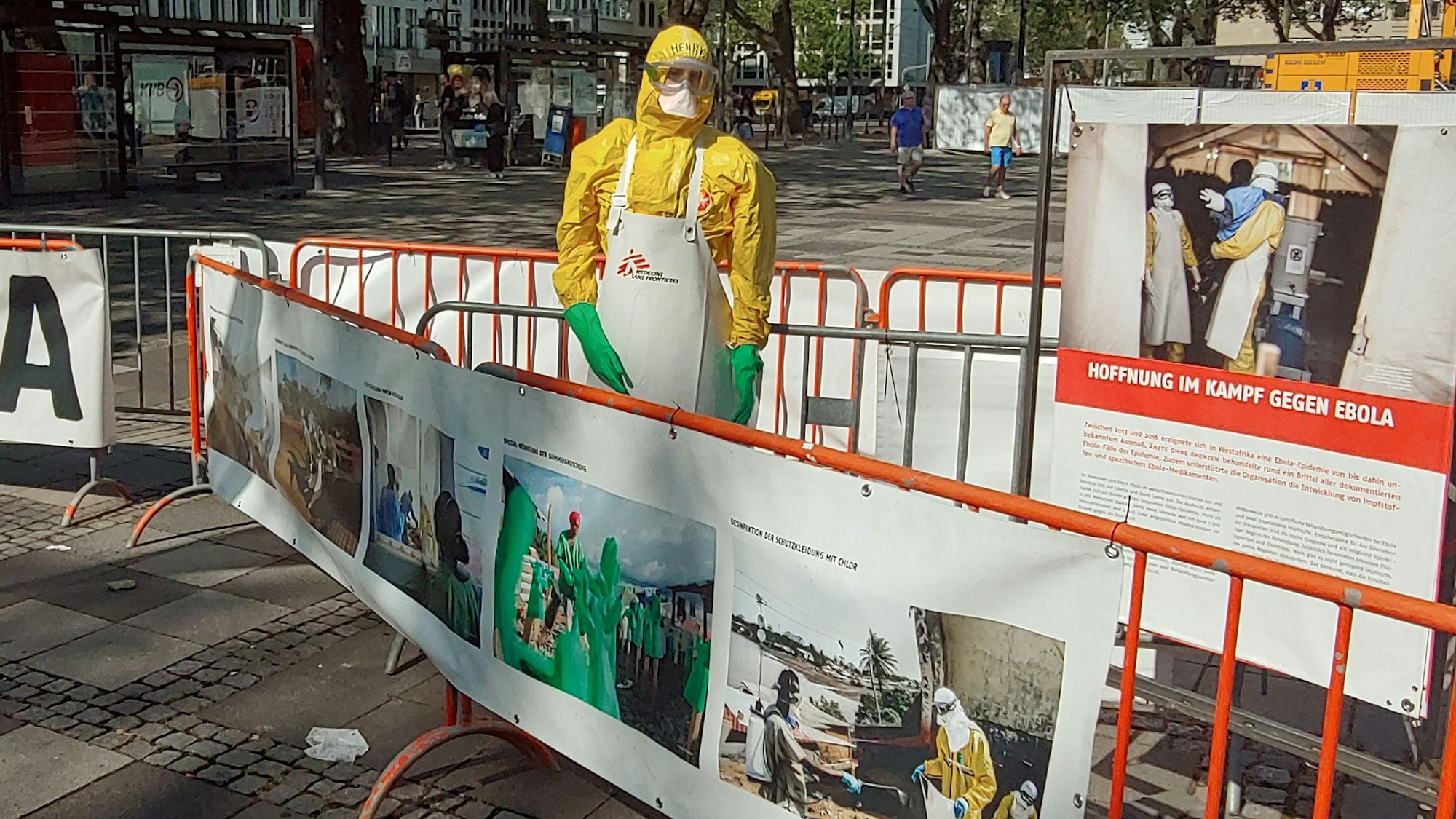 Person in gelber Schutzausrüstung zwischen zwei Absperrungen