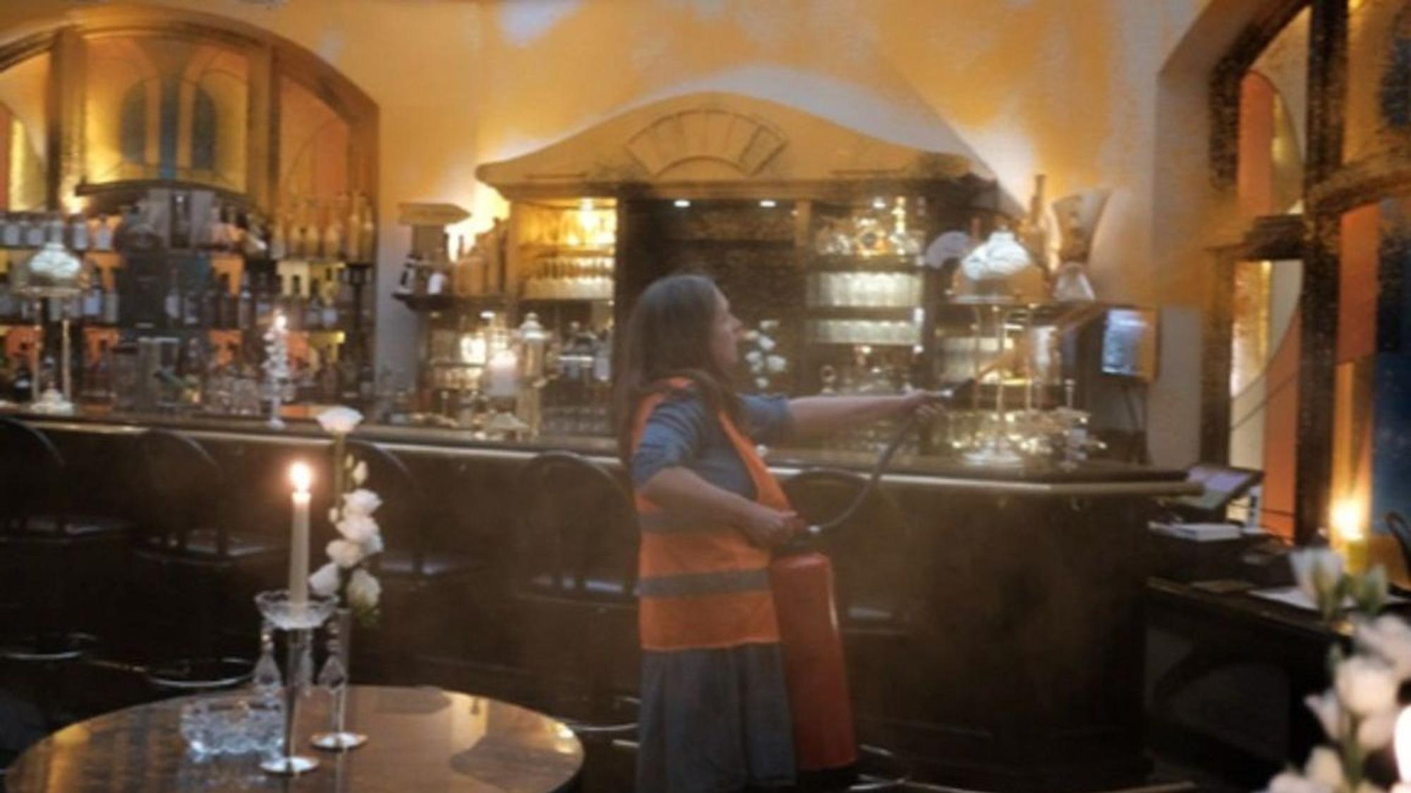 Protestaktion auf Sylt: Eine Aktivistin der Letzten Generation versprüht in einer Luxus-Bar auf der Urluabsinsel organe Farbe. Das Foto wurde von der Letzten Generation bereitgestellt.