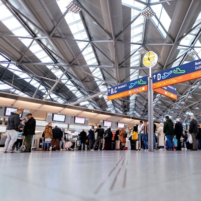 Zu sehen ist eine Halle im Flughafen Köln/Bonn in der Menschen warten.