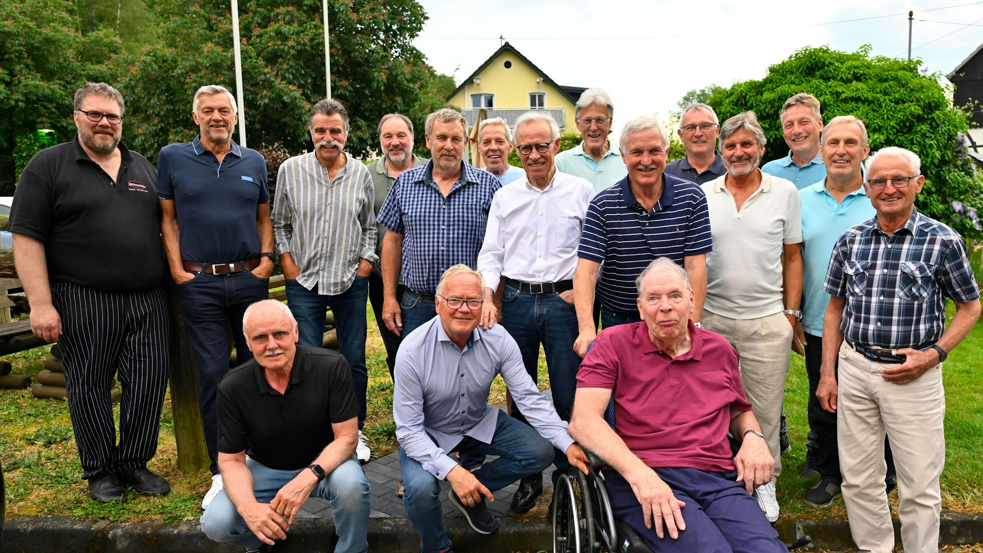 Eine Gruppe von Männern steht beisammen. Einer von ihnen sitzt im Rollstuhl.