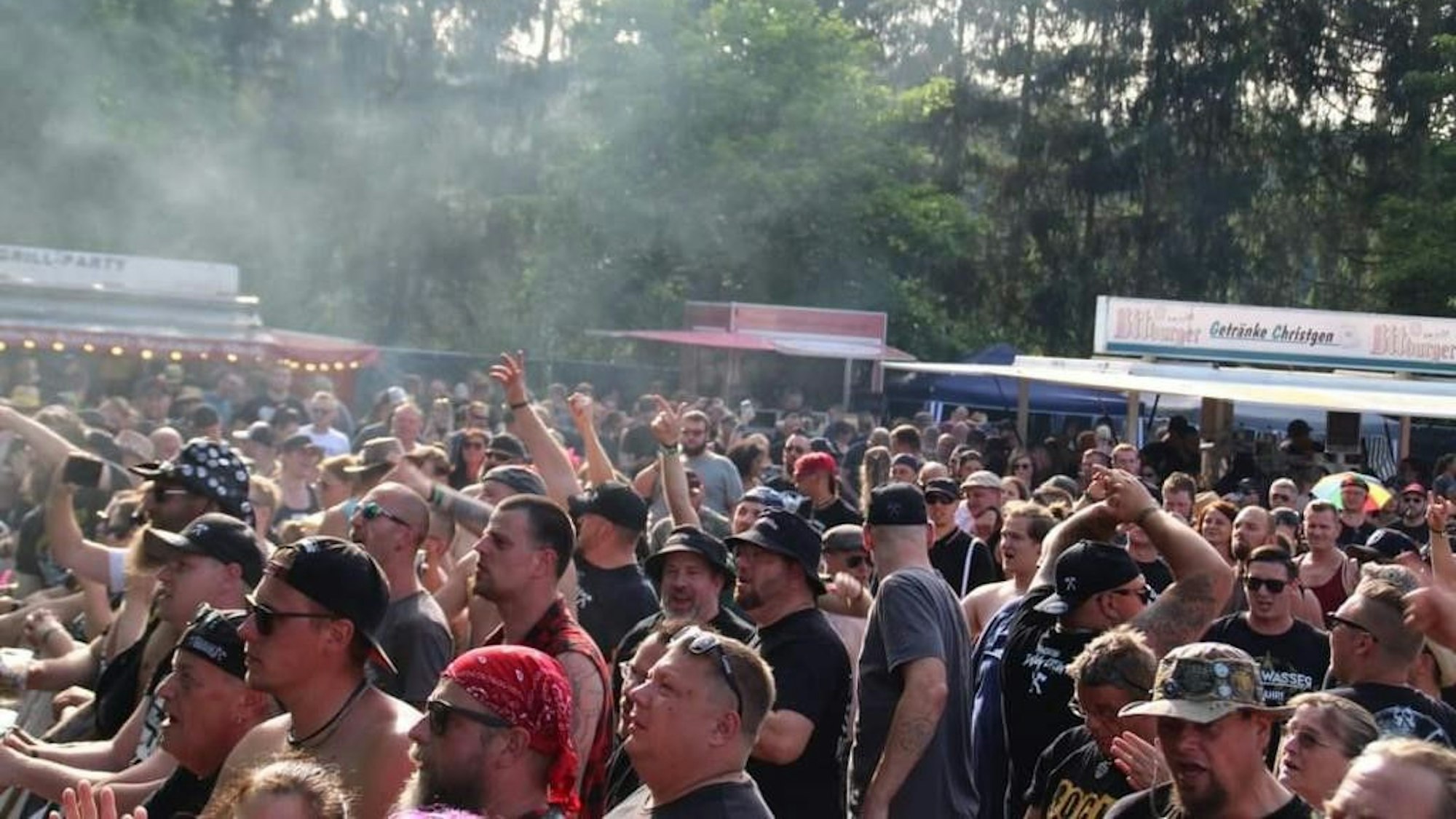 Menschen stehen in einer Menge vor einer Bühne.