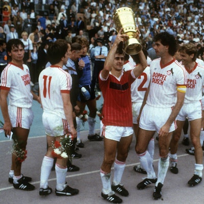 Spieler des 1. FC Köln freuen sich über den Pokalsieg. Einer stemmt die Trophäe in die Höhe.