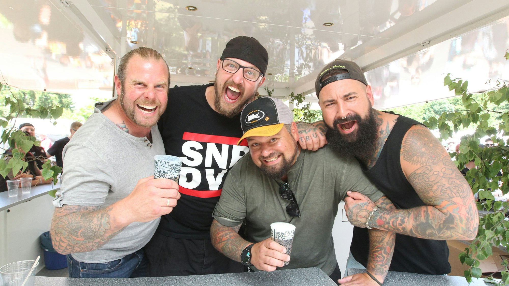 Vier Männer stehen in einem Bierpilz.