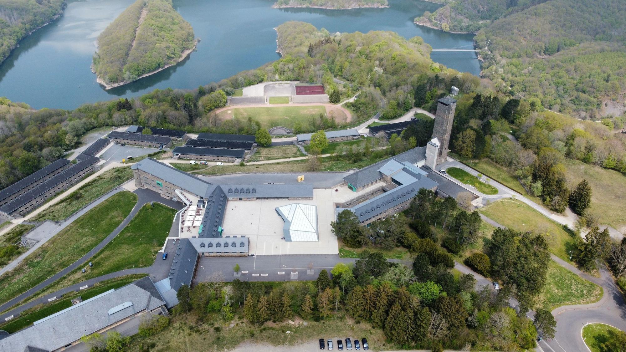 Das Luftbild zeigt die von den Nationalsozialisten erbaute Vogelsang-Anlage, im Hintergrund den Urftsee.