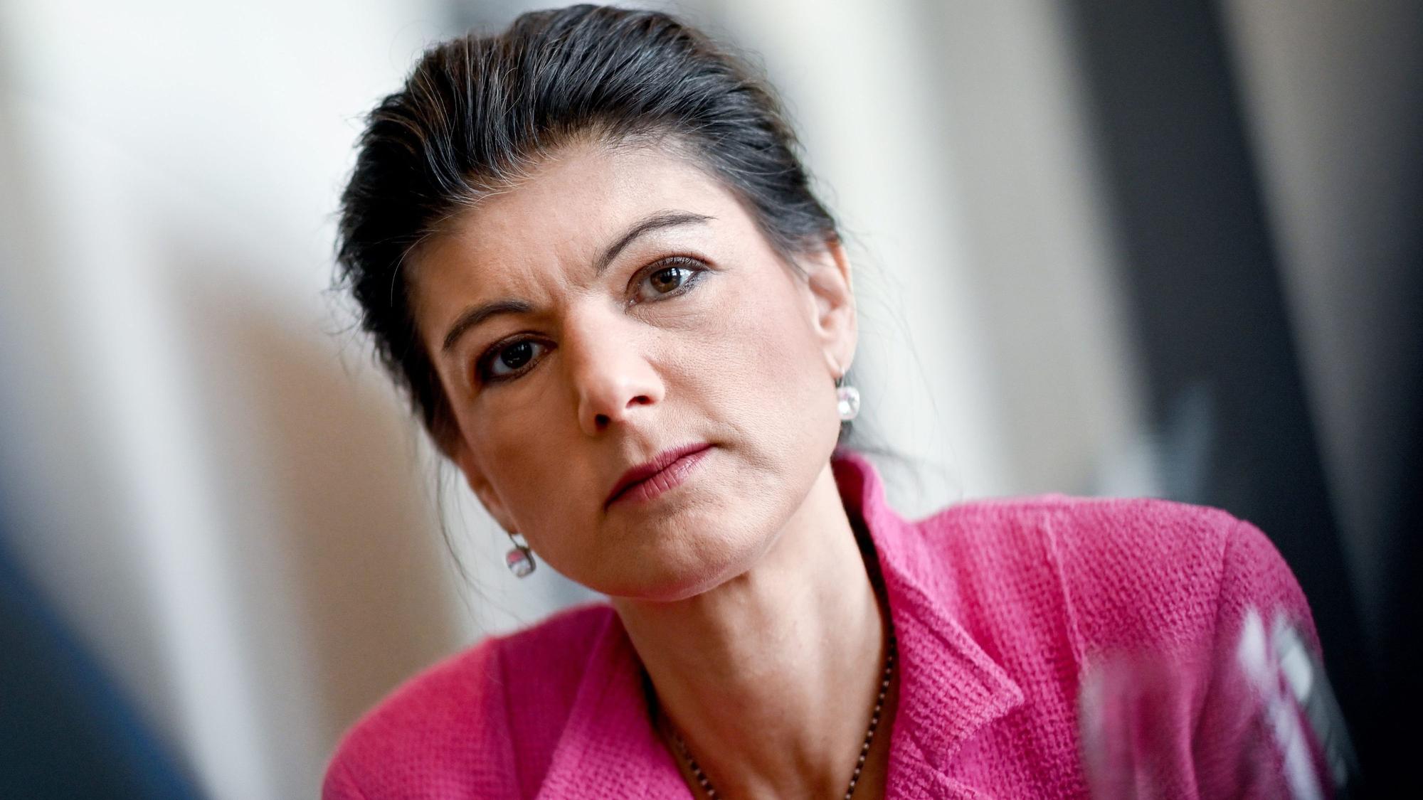 Sahra Wagenknecht, damals Fraktionsvorsitzende der Partei Die Linke, steht im Bundestag am Rande eines dpa-Interviews. Sie trägt eine pinke Jacke und blickt in die Kamera. (Archivbild)