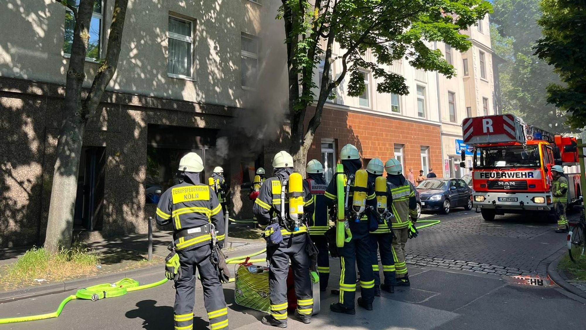 Dichter Rauch kommt aus dem Bestattungsunternehmen in Humboldt. Davor stehen Feuerwehrleute.