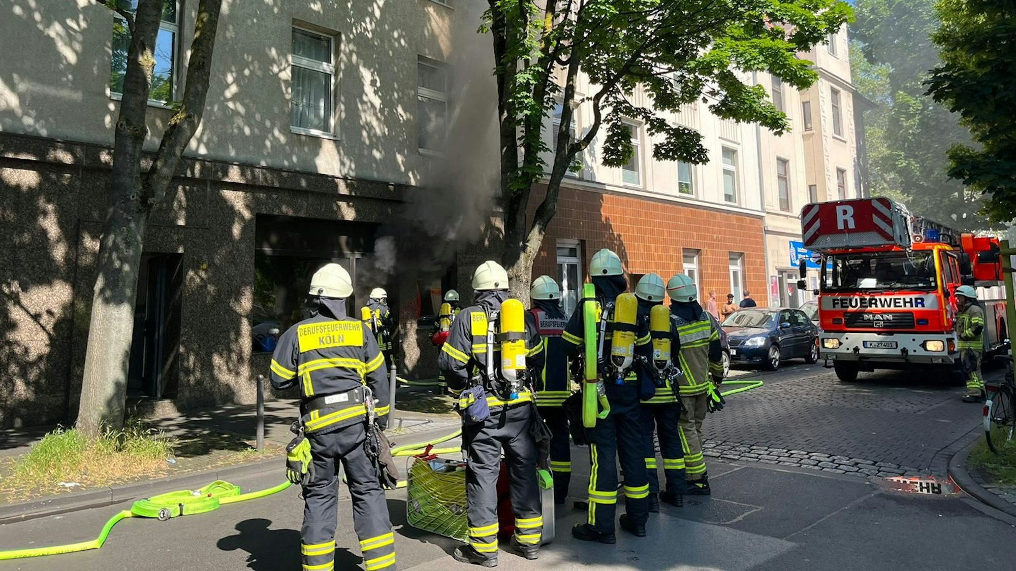 Dichter Rauch kommt aus dem Bestattungsunternehmen in Humboldt. Davor stehen Feuerwehrleute.