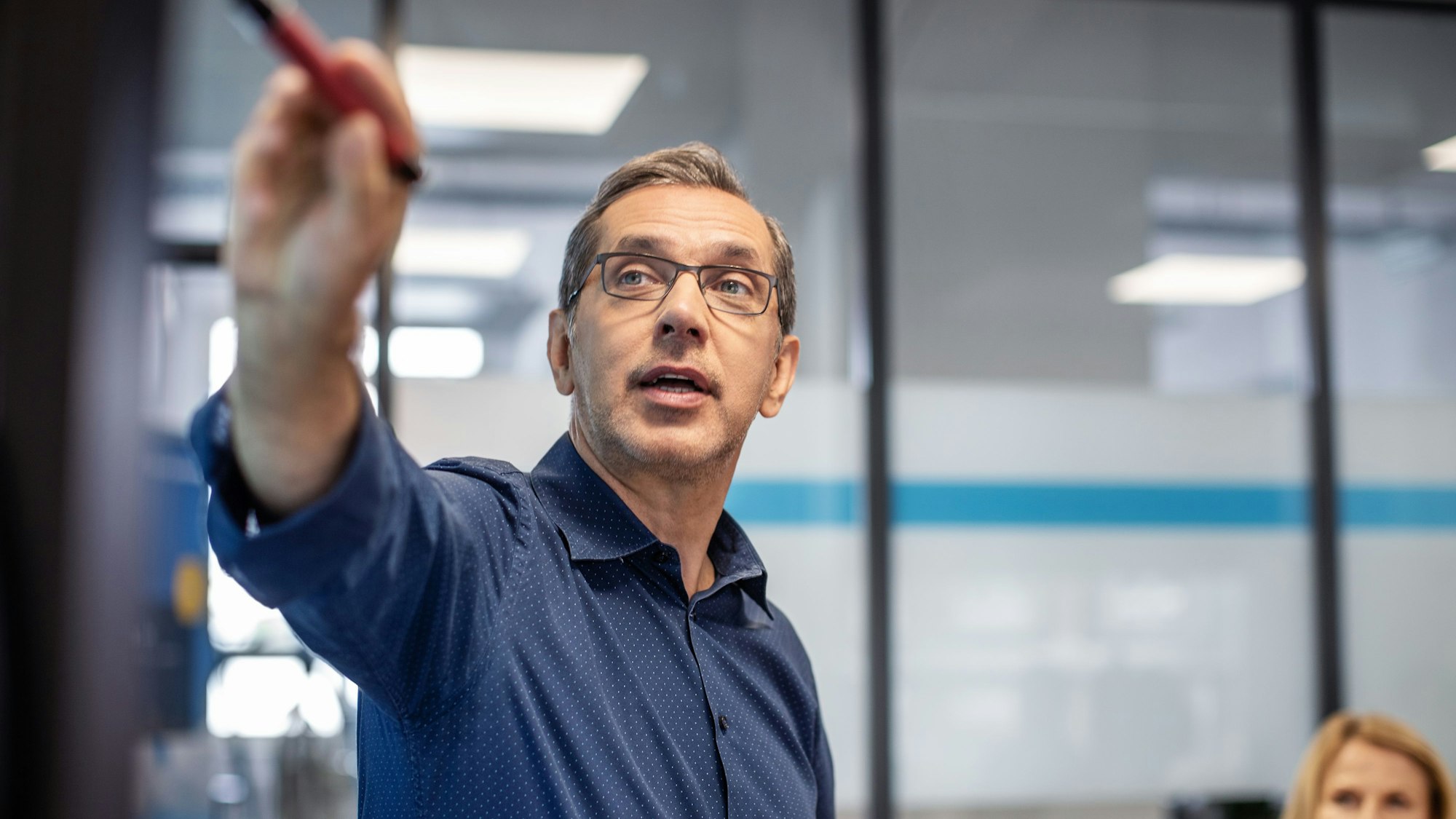 Ein Mann in einem Hemd hält in einem Konferenzraum einen Vortrag