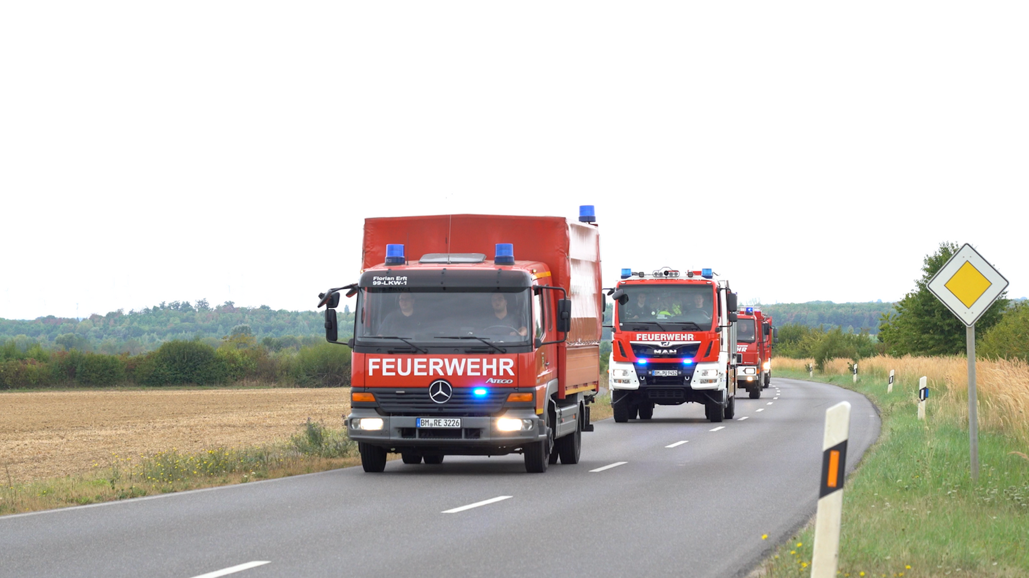 Auf dem Foto sind Feuerwehrfahrzeuge zu sehen, die im Konvoi fahren.