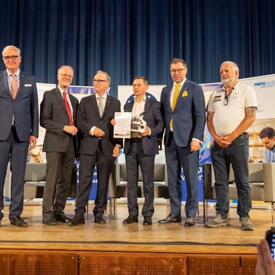 Männer stehen auf einer Bühne.