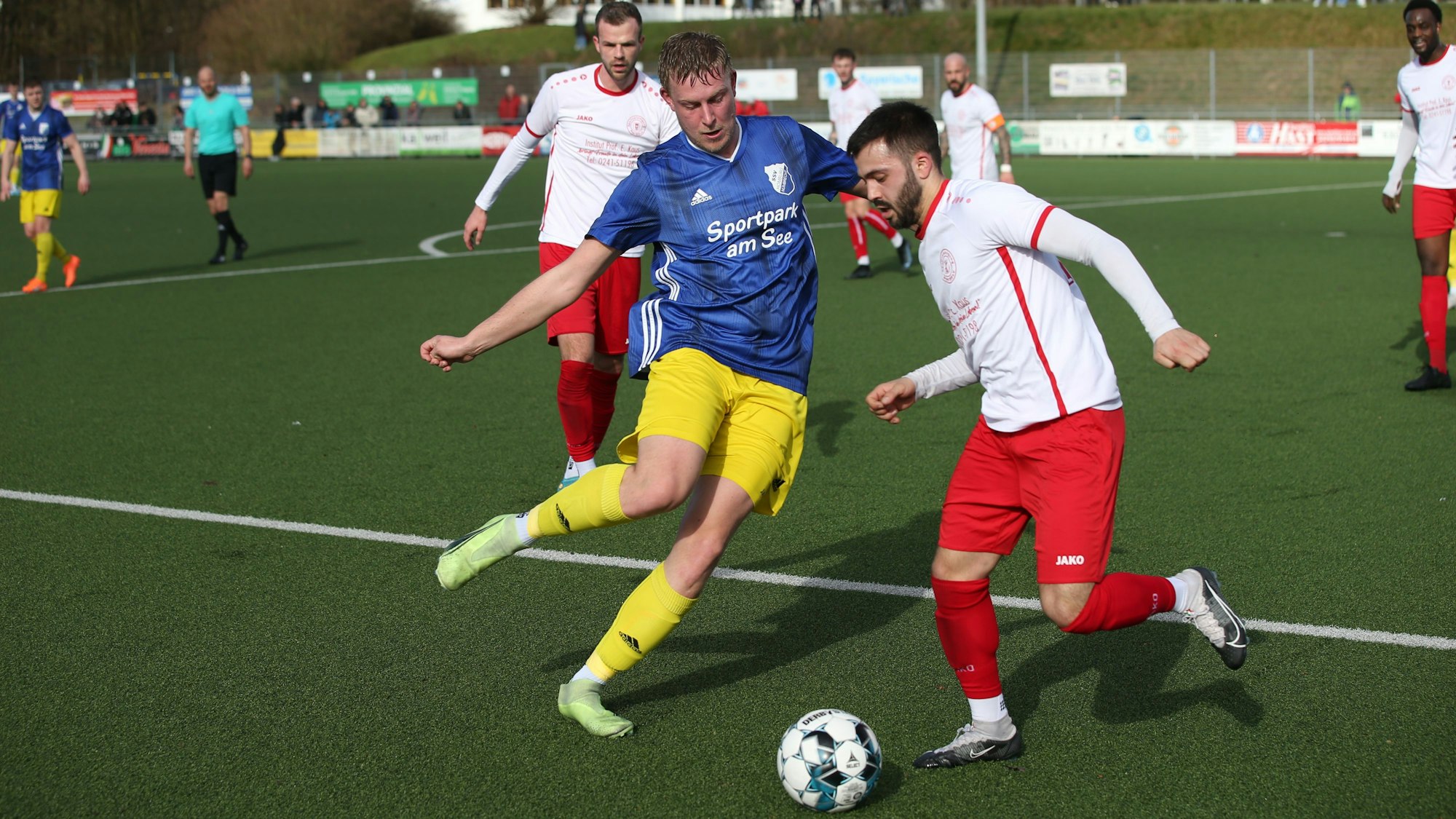 Zwei gegnerische Fußballspieler in einer Spielsituation.