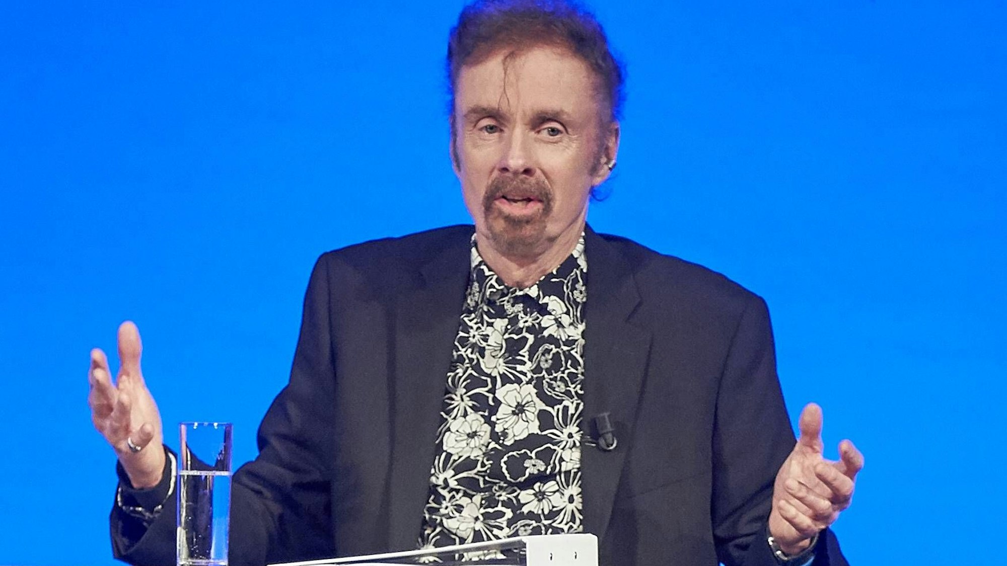 T. C. Boyle bei einer Lesung mit schwarz-weiß geblümten Hemd.