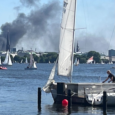 Eine Rauchwolke ist über der Alster in Hamburg zu sehen.