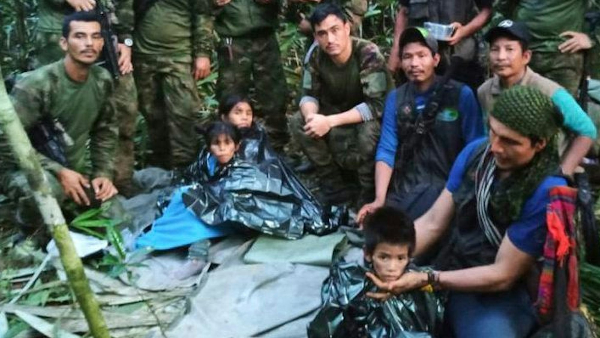 Kolumbien, Solano-Dschungel: Auf diesem von der Pressestelle der kolumbianischen Streitkräfte veröffentlichten Foto posieren Soldaten und indigene Männer für ein Foto mit den vier Geschwistern, die nach einem tödlichen Flugzeugabsturz vermisst wurden.