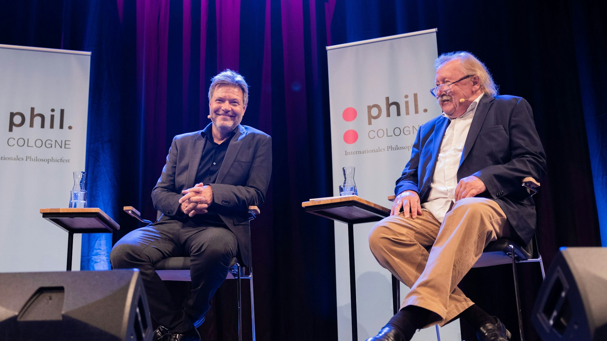 Robert Habeck (l, Bündnis 90/Die Grünen), Bundesminister für Wirtschaft und Klimaschutz, und Peter Sloterdijk, Autor, sitzen im Rahmen der Phil.Cologne im Funkhaus auf der Bühne. Die Beiden sprechen über die Menschheit, das Feuer und das Klima.