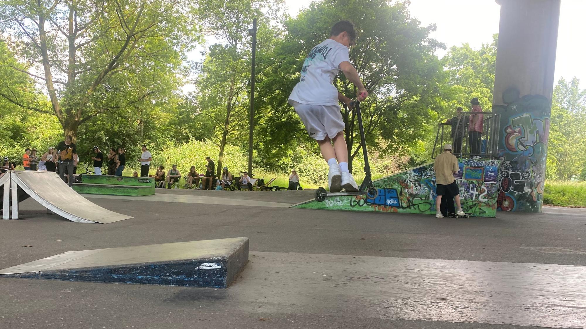 Sam Louis Strezel springt auf seinem Scooter über eine Rampe.