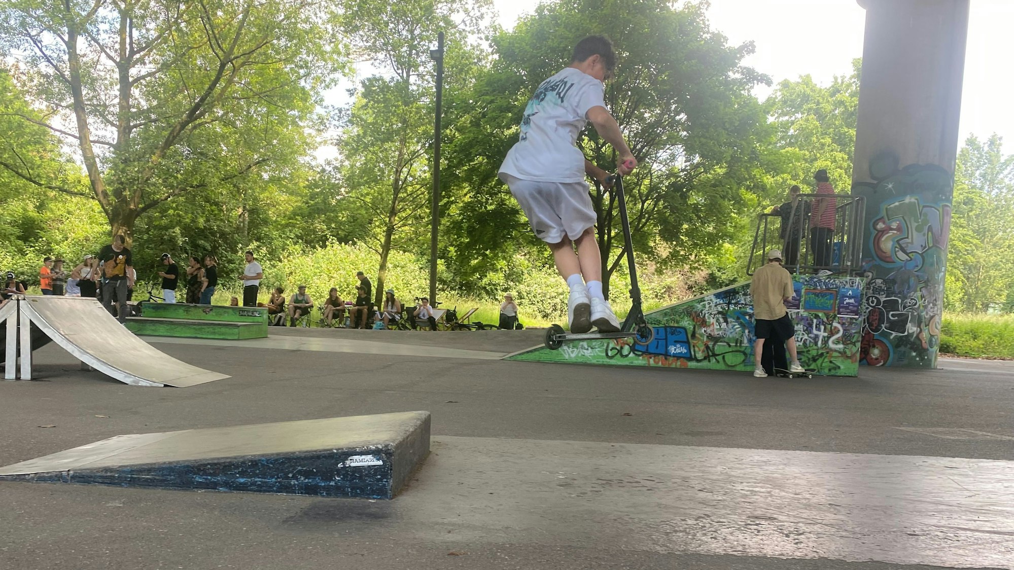 Sam Louis Strezel springt auf seinem Scooter über eine Rampe.