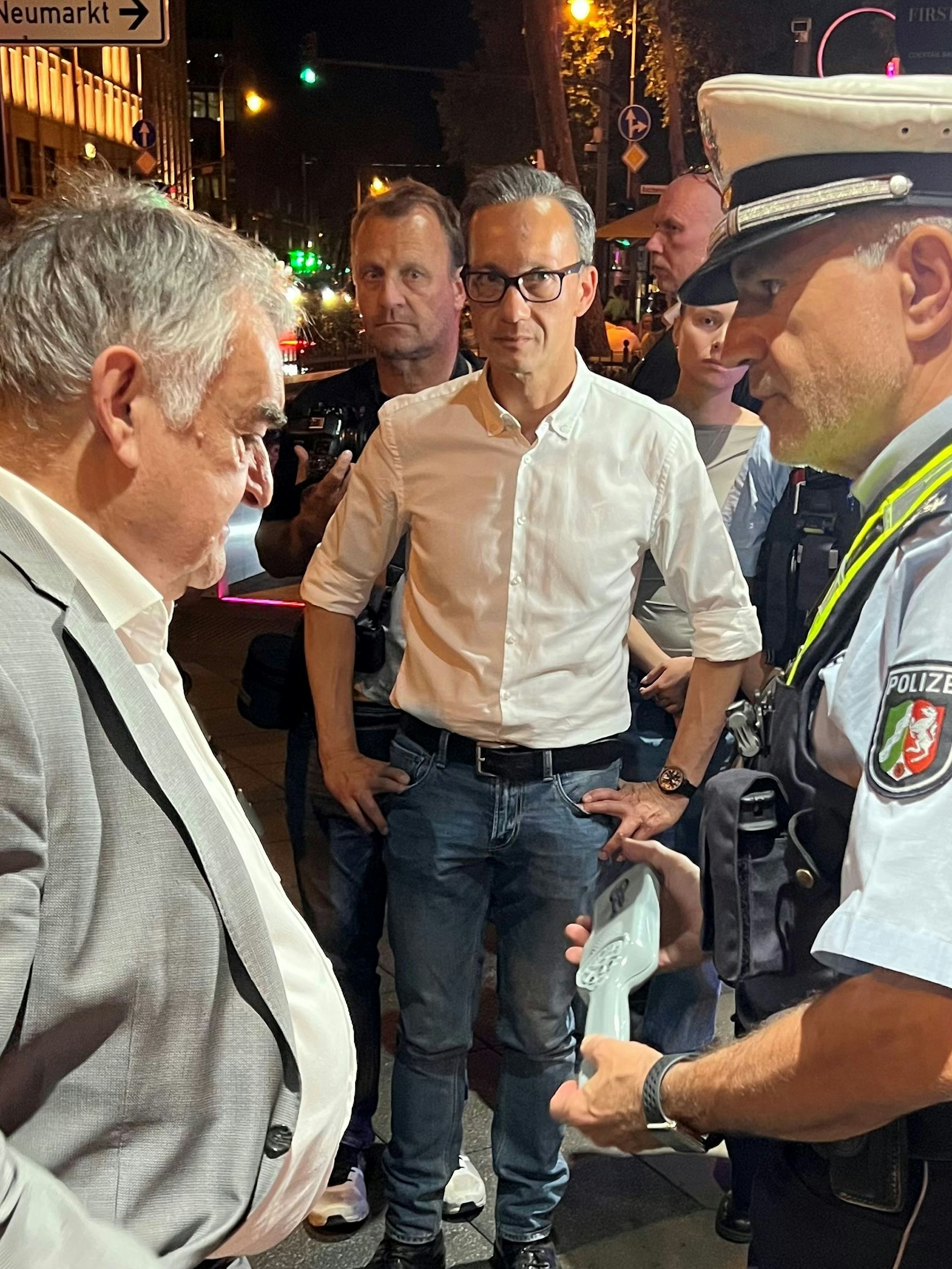 Herbert Reul lässt sich von einem Beamten einen Metalldetektor erklären.