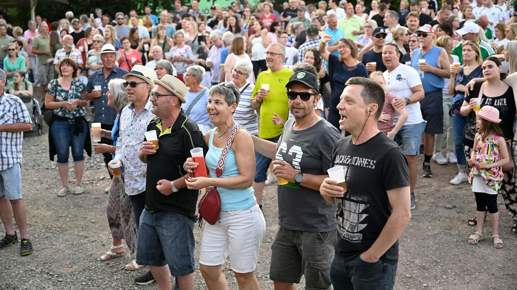 Ungefähr 1.000 Menschen stehen vor einer Bühne.
